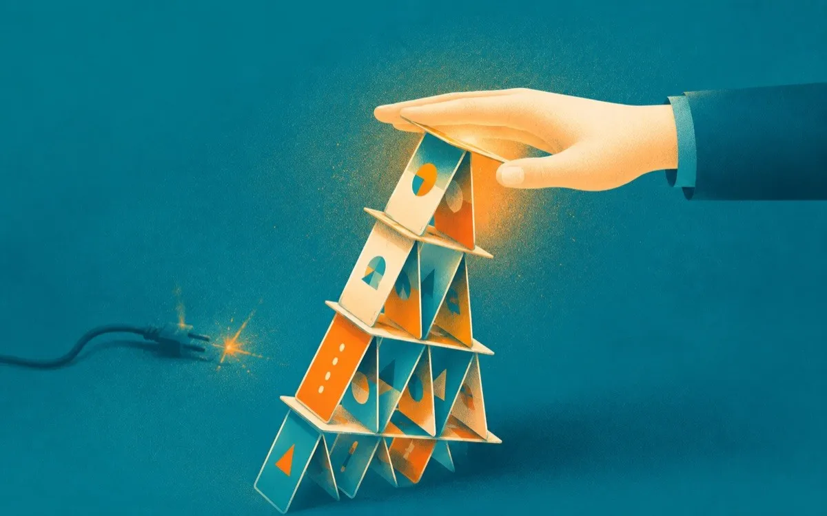 A hand steadying a leaning house of cards beside an unplugged sparking cable, a metaphor for recovering when a presentation goes wrong